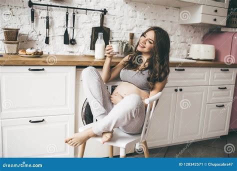 Beautiful Pregnant Woman In Kitchen With Cup Of Milk Stock Image