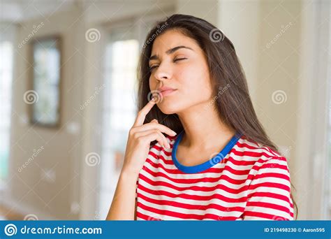 joven hermosa mujer pensando y preguntándose con una mano en la barbilla duda concepto foto de