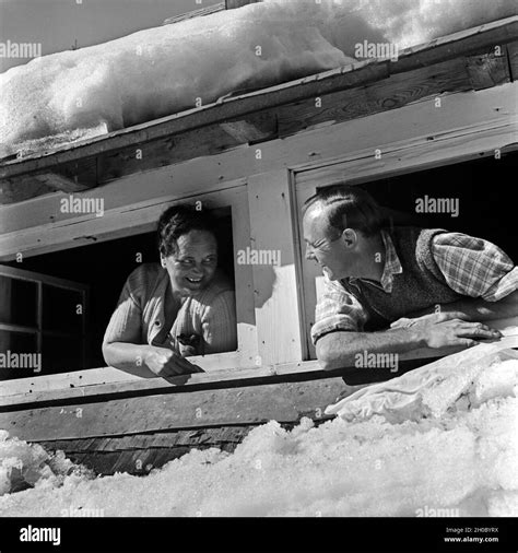 eine frau und ein mann unterhalten sich aus ihren dachfenstern deutschland 1930er jahre a man