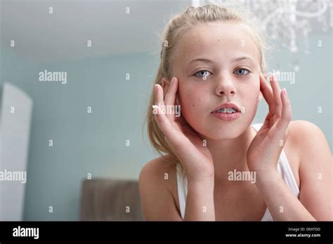 Teenage girl touching her face Stock Photo - Alamy