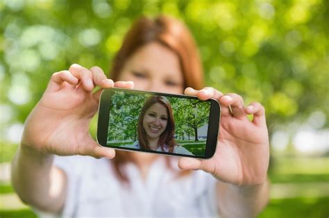 Premium Photo Pretty Redhead Taking A Selfie On Her Phone In The Park