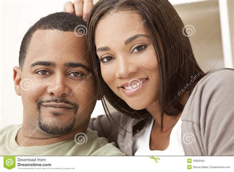 Happy African American Couple Sitting At Home Stock Photo