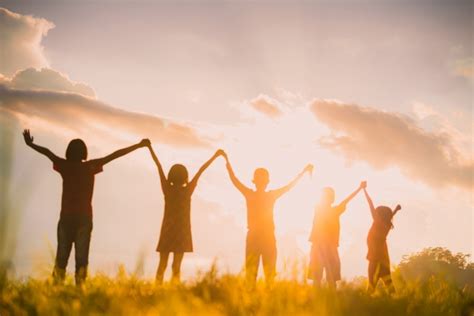 The Silhouette Of The Children Holding Hands Enjoying The Sunset A