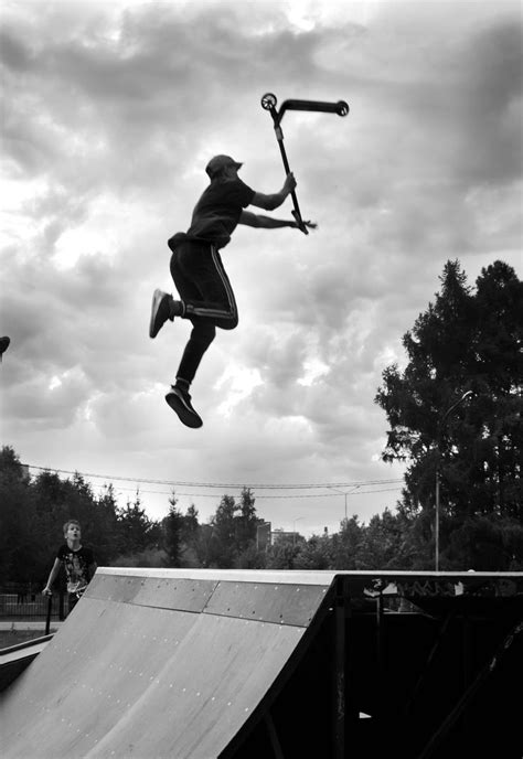 A Man Flying Through The Air While Riding A Skateboard On Top Of A Ramp
