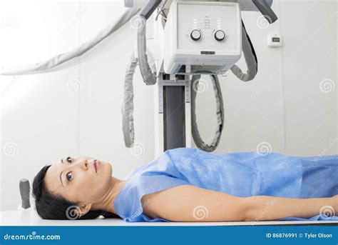 Female Patient Lying Under X Ray Device In Examination Room Stock Photo
