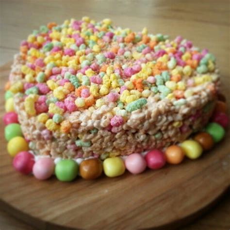 A Cake Covered In Cereal And Candy On Top Of A Wooden Board