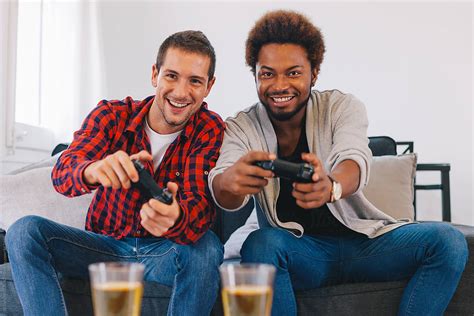 Two Happy Young Friends Playing Video Games At Home By Stocksy