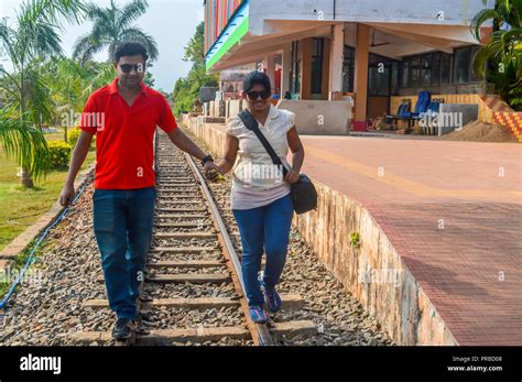The Young Couple Walking On A Railway Track Traveler Having Fun At Railway Station Holding