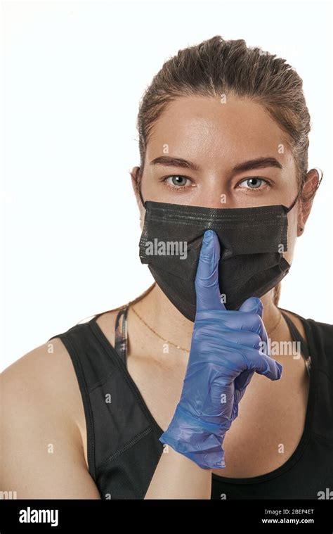 a close up portrait of a pretty female wearing a surgical mask isolated on a white background