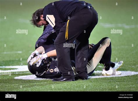 Injured Football Player Being Treated On The Field By Training Staff