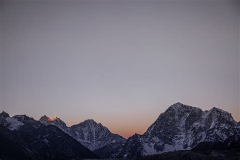 Tall Peaks And Sharp Ridges Stretch To The Horizon Under A Pale Blue