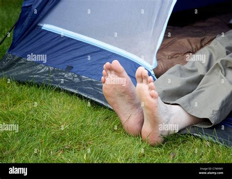 Mans Bare Feet Sticking Out Of The Door Of A Small Dome Tent Model
