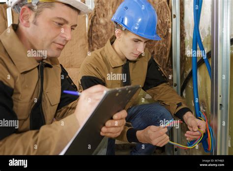 Teacher Observing Student Working On Electrical Circuits Stock Photo