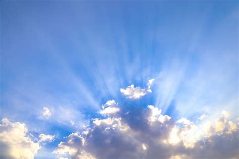Luz A Través De Las Nubes Sobre Fondo De Cielo Azul Brillante Foto