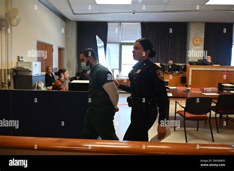 Cesar Santana in court wearing a jailhouse uniform and handcuffs. Cesar