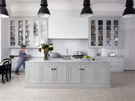 White cabinets brighten a kitchen and make space feel much more open and light. greige painted kitchen, black lights, white handmade tiles ...