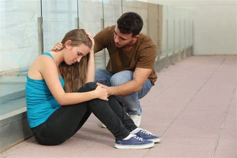 Beautiful Teenager Girl Worried And A Boy Comforting Her Stock Photo