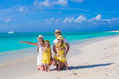 Familia Feliz Que Presenta En La Playa Durante Tropical Foto De Archivo