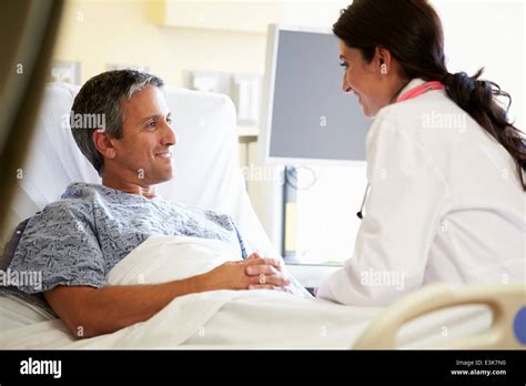 Female Doctor Talking To Male Patient In Hospital Room Stock Photo Alamy