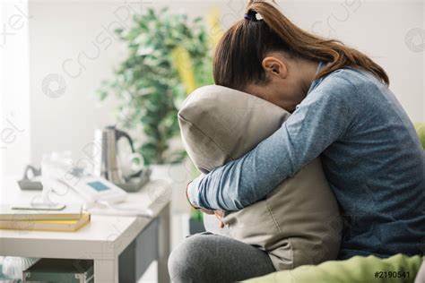 triste mujer abrazando una almohada foto de stock crushpixel