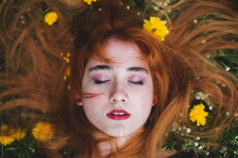 Ginger Haired Woman Laying In Flowers By Stocksy Contributor Jovana
