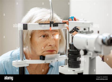 Senior Woman During A Medical Eye Examination With Microscope In The Ophthalmologic Office Stock