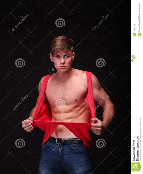 Handsome Young Man Tearing Shirt Off On A Black Background Fitness And