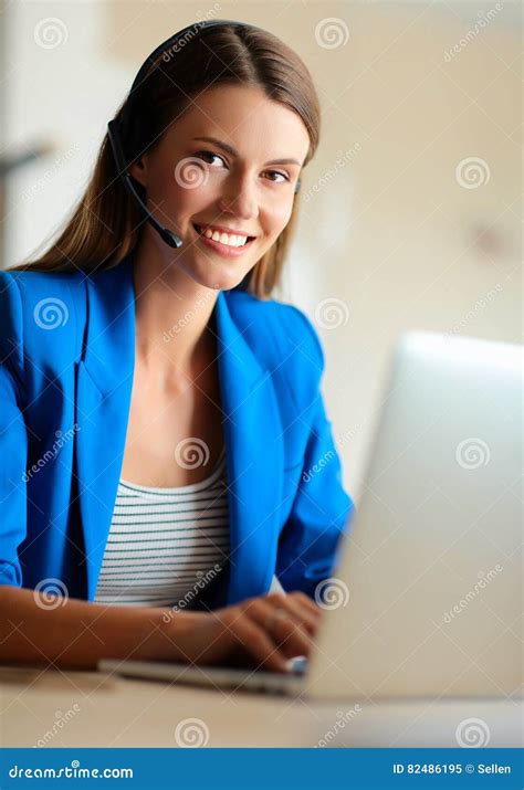 Portrait Of Beautiful Business Woman Working At Her Desk With Headset