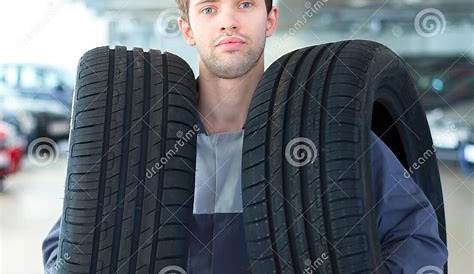 Repairmen Automobile Mechanic with Car Tire Stock Photo - Image of