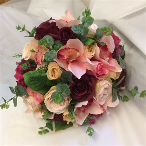 A Brides Bouquet Featuring Burgundy Peach And Blush Pink Flowers