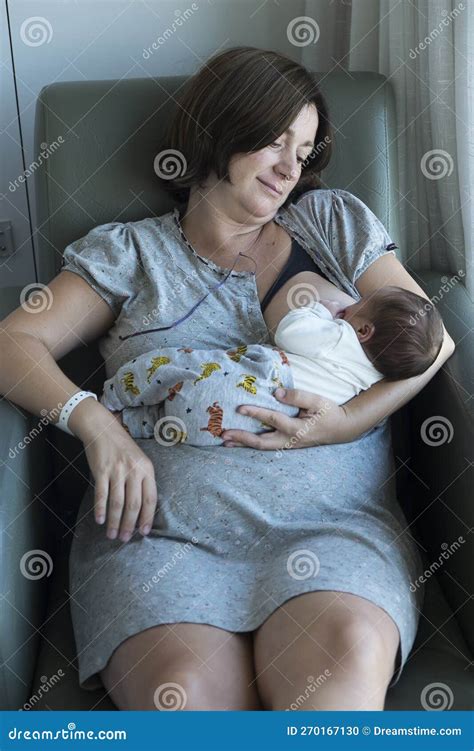 Mom Breastfeeds Her Newborn Baby In The Maternity Hospital Stock Photo