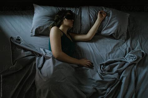 Woman With Sleeping Mask Lying In Bed Del Colaborador De Stocksy