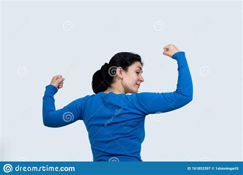 Portrait Of A Happy Woman Showing Her Biceps On Gray Background Strong