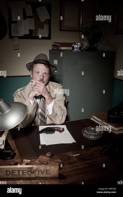 Confident Detective Smoking At Desk In Trench Coat 1950s Film Noir