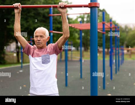 Elderly Man Hanging From Pullup Bar And Doing Pull Ups Stock Photo Alamy