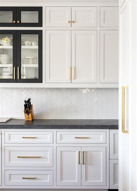 White shaker cabinetry with black countertops and glass by south shore decorating. White shaker kitchen cabinets with various black frame cabinet doors accented with b… | White ...
