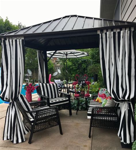 A Black And White Striped Gazebo Sitting Next To A Pool With Chairs