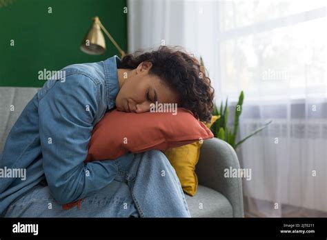 beautiful woman sleeping at home on sofa hugging pillow hispanic woman tired sleeping in