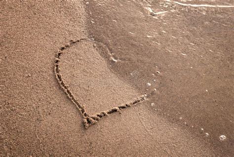 Heart On A Sand Of Beach With Wave On Background Heart Shape Drawn On