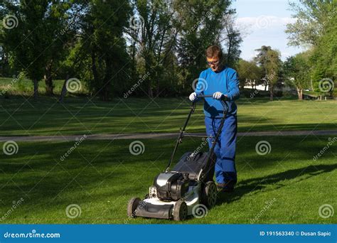 The Worker Mows The Lown Maintenance Of Greenery Image Stock Photo