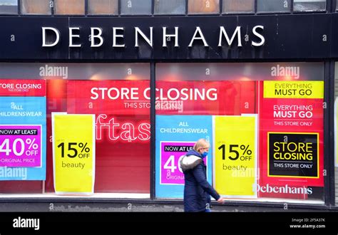 A Woman Walks Past A Window Of A Debenhams Store In Manchester Greater Manchester England