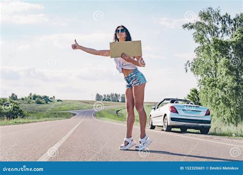 Lauto Stoppeuse De Sourire De Femme Sur La Route Tient Un Conseil Vide Image Stock Image Du