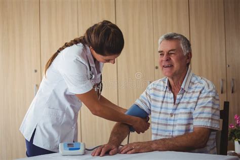 Nurse Measuring The Blood Pressure Of A Senior Man Stock Photo Image