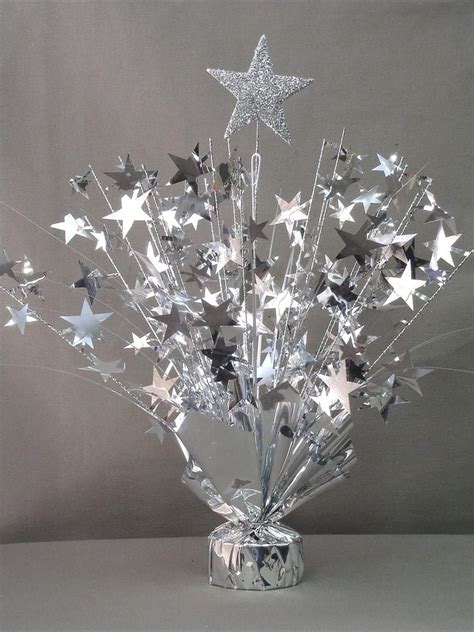 A Silver Vase Filled With Stars On Top Of A Table