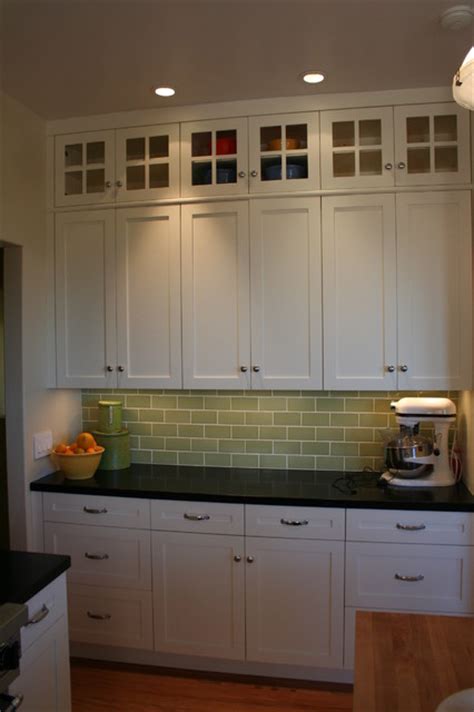 Having glass kitchen cabinets doesn't mean you have to replace your cabinets. Glass doors on top lighten the bank of cabinets without ...