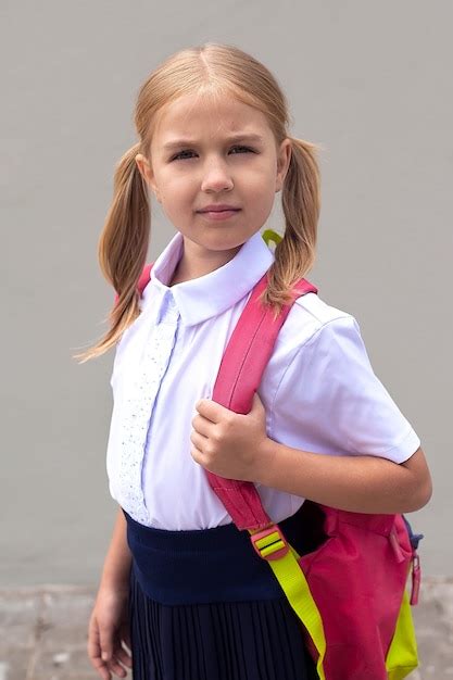 Premium Photo A Beautiful Little Schoolgirl With A Pink Backpack Walks In The Park The