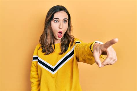 Young Hispanic Girl Wearing Casual Clothes Pointing With Finger Surprised Ahead Open Mouth