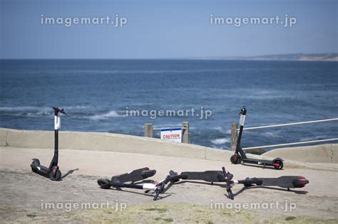 Four Abandoned Electric Scooters La Jolla Cove Overlooking Oceanの写真素材