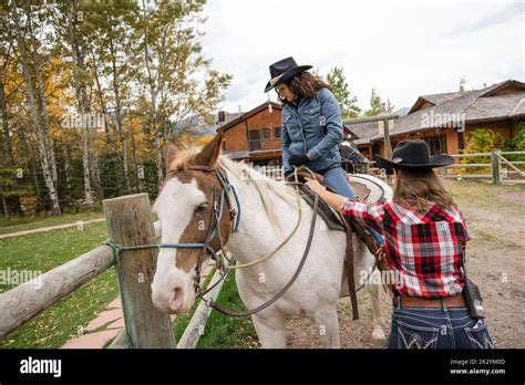 Rancher Helping Woman Mount Horse For Horseback Riding Stock Photo Alamy