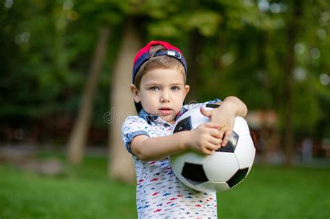 Little Child Hand Holding Football And Playing Soccer Ball Stock Image